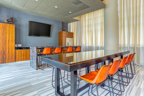 A conference room with a long table and orange chairs.