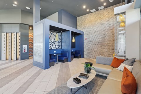A modern living room with a blue sofa and a glass table.