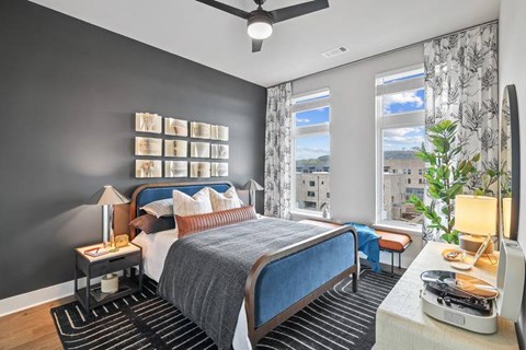 A bedroom with a large bed and a view of the city.