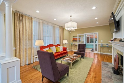 A living room with a purple chair and a red couch.