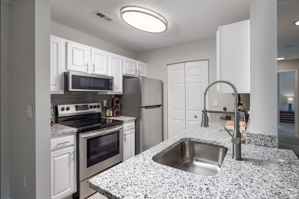 A kitchen with granite countertops and stainless steel appliances.