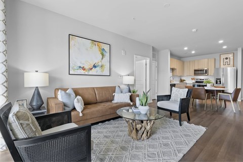 A modern living room with a brown sofa and a glass coffee table.