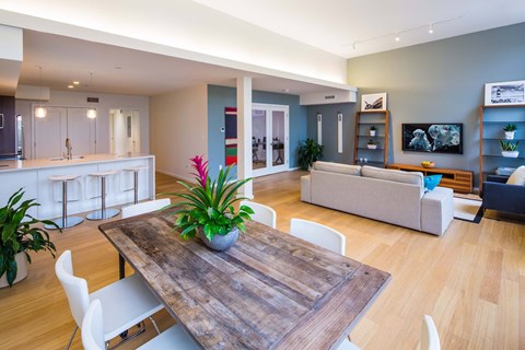 A modern living room with a wooden table and white chairs.