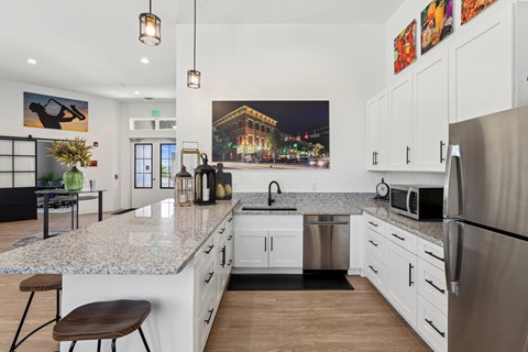 A modern kitchen with a granite countertop and stainless steel appliances.