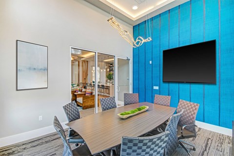 A conference room with a long table and chairs.