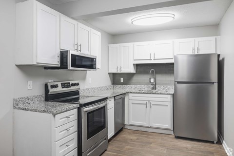 A kitchen with white cabinets and stainless steel appliances.