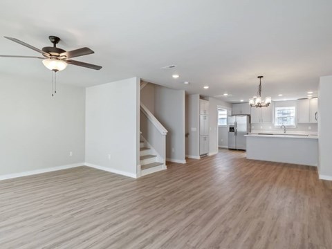A spacious room with a ceiling fan and wooden flooring.