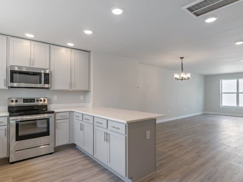 A kitchen with white cabinets and stainless steel appliances.