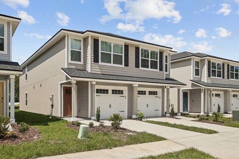 A row of houses with garages and driveways.