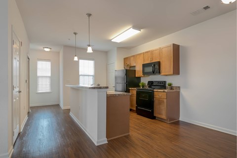 A kitchen with wooden cabinets and a black oven.