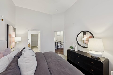 A bedroom with a large bed and a mirror on the wall.
