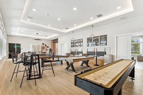 A pool table is in the middle of a room with a long table and chairs.