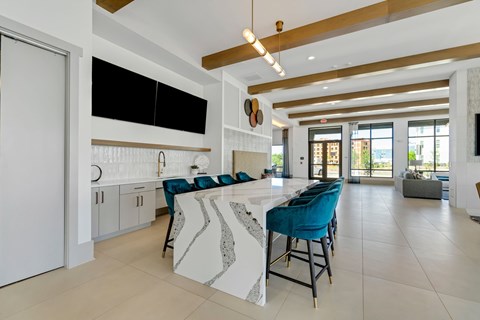 a large kitchen with a long island with blue chairs