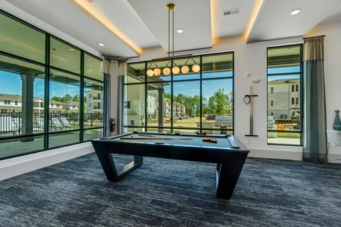 a pool table in a room with windows