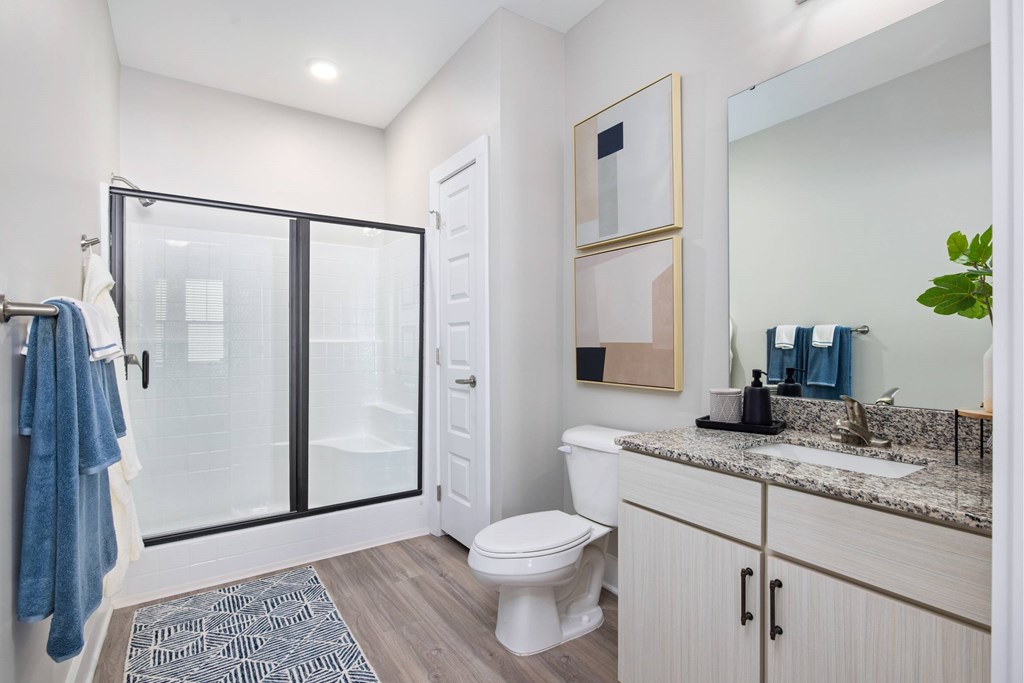 A bathroom with a toilet, sink, and mirror.