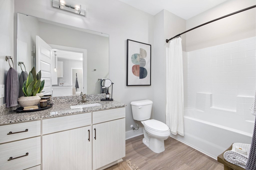 A white bathroom with a toilet, sink, and mirror.