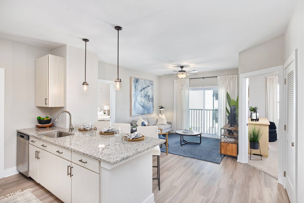 A kitchen with a marble countertop and a dining area with a table and chairs.