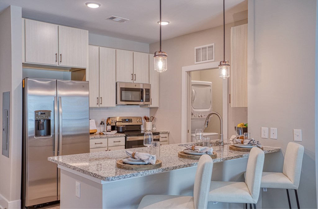 A modern kitchen with a granite countertop and stainless steel appliances.