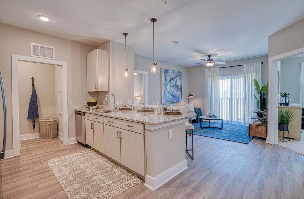 A well-lit, spacious kitchen with light wood flooring and a large island.