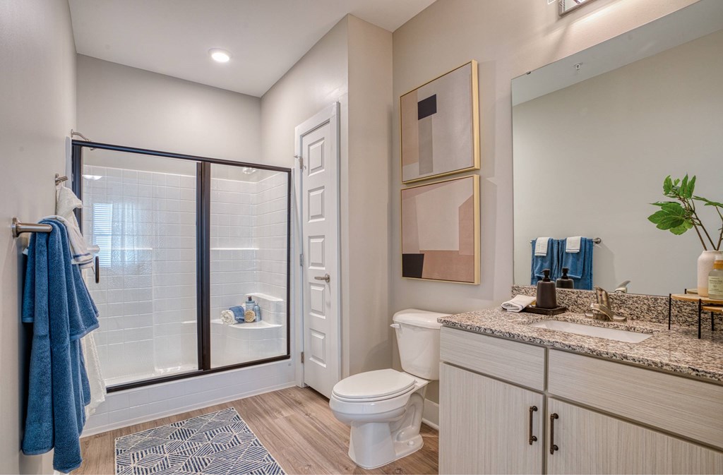 A bathroom with a toilet, sink, and shower.