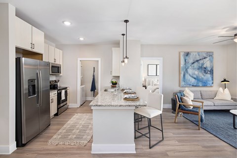A modern kitchen with a breakfast bar and a couch in the living room.