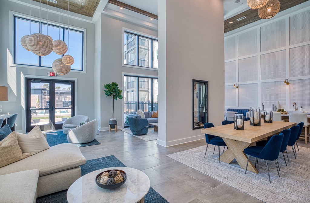 A modern living room with a large window and a dining area.