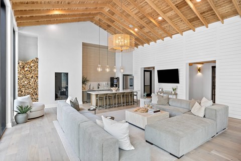 A modern living room with a grey sofa and a wooden ceiling.