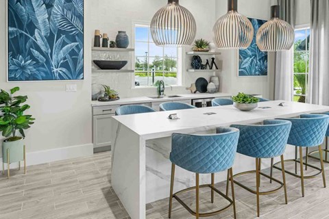 A kitchen with a white counter and blue chairs.