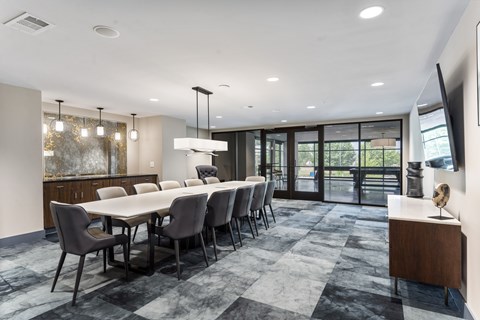 A modern dining room with a large table and chairs.