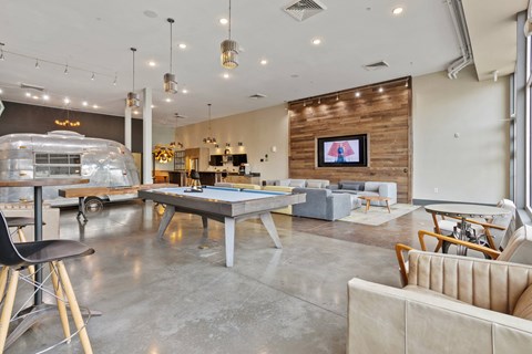 A modern living room with a pool table and a bar area.