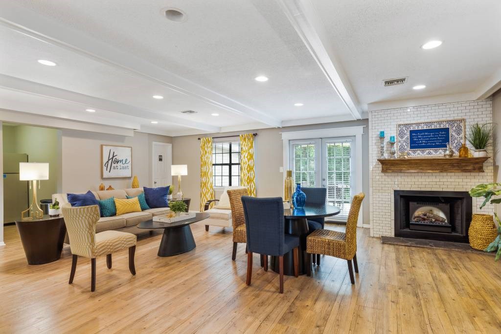A living room with a fireplace and a dining table set up.