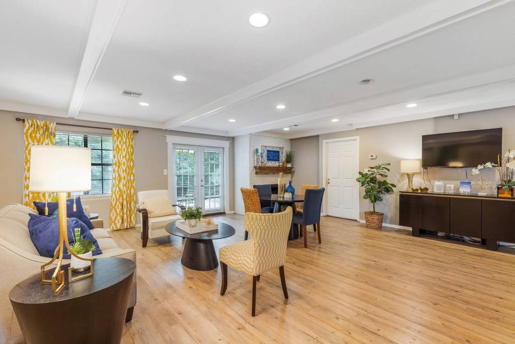 A well-lit living room with a sofa, chairs, and a coffee table.