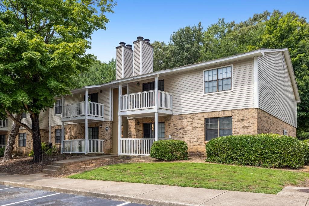 A two-story apartment building with a balcony on the second floor.