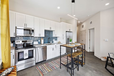 A modern kitchen with a dining table and chairs.