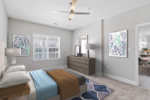 A bedroom with a bed, dresser, and ceiling fan.
