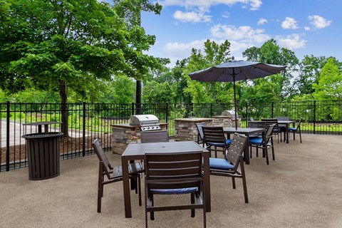 A patio with a table and chairs and an umbrella.