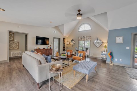 A living room with a white couch and a glass coffee table.