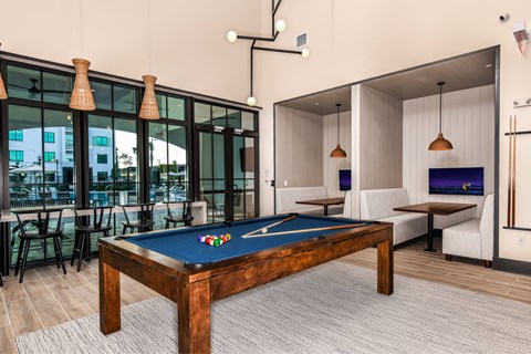 A pool table in a room with a view of the outside.