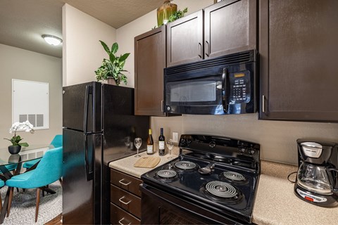 A black stove top oven sits on a countertop in a kitchen.