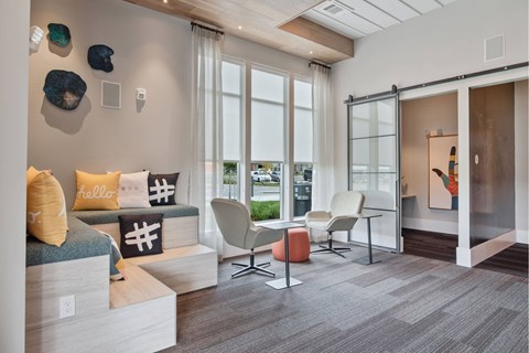 A living room with a sofa, chairs, and a painting on the wall.