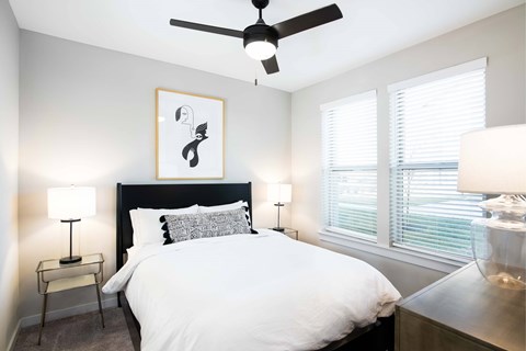 Dog-Friendly Apartments in Nashville, TN - The Sound at Pennington Bend - Bedroom With Ceiling Fan, Bedside Lamps, Wall Art, Dresser, Hardwood-Inspired Plank Flooring, and Large Windows With Blinds.
