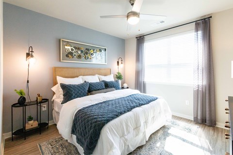 A bedroom with a large bed and a ceiling fan.
