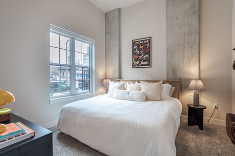 A bedroom with a large bed and a painting on the wall.