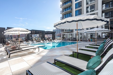 A sunny day at the pool with lounge chairs and umbrellas.