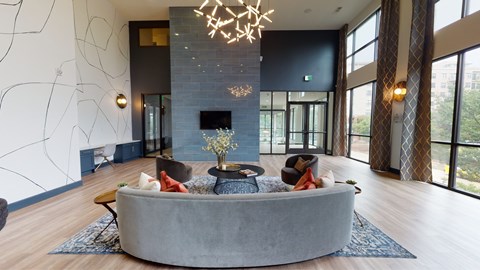 A modern living room with a grey sofa and a chandelier.