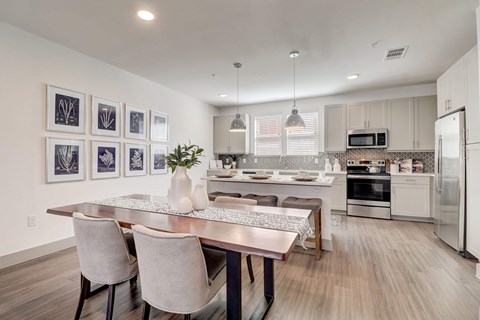 A modern kitchen with a dining table and chairs.