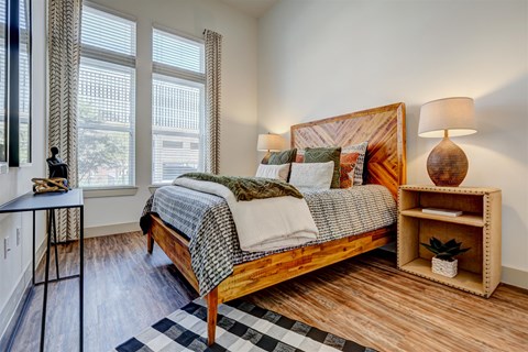 a bedroom with a bed and two windows
