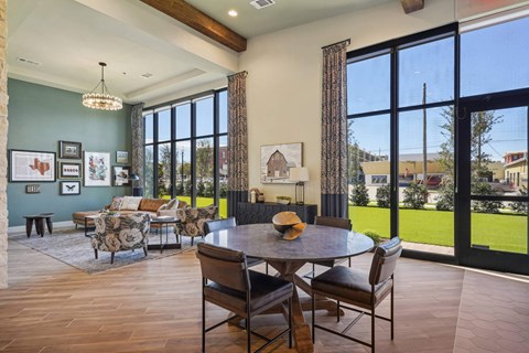 a large living room with large windows and a table and chairs