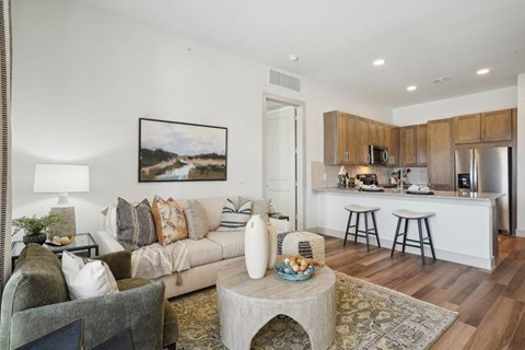 A living room with a grey couch and a coffee table with a vase on it.