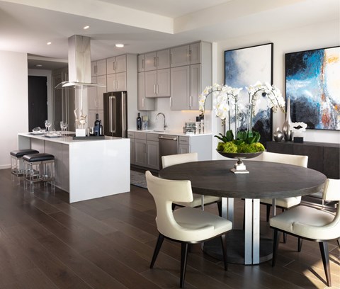 A modern kitchen with a dining table set for four.